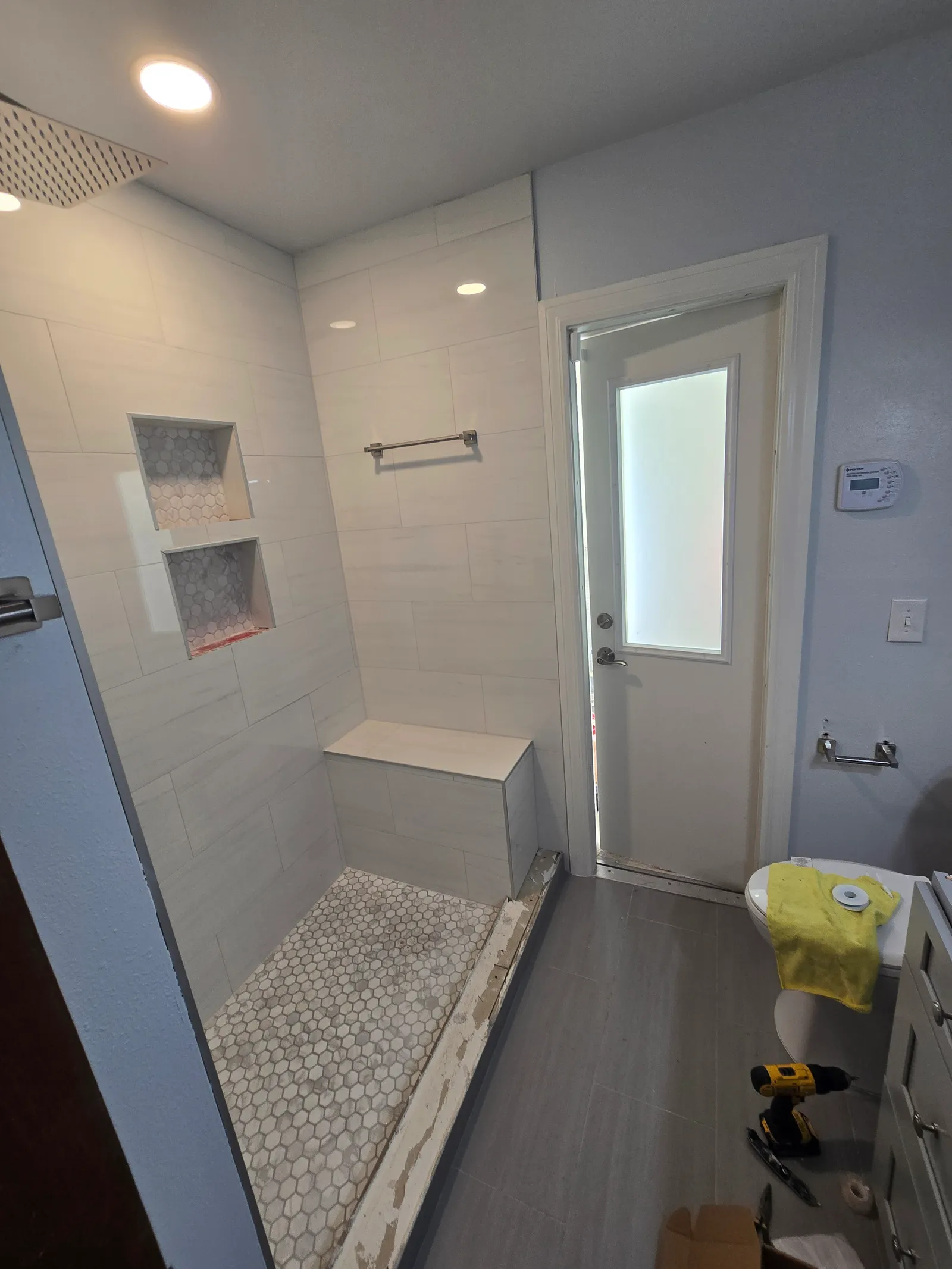 Walk-in shower with bench, mosaic floor and new door after the conversion
