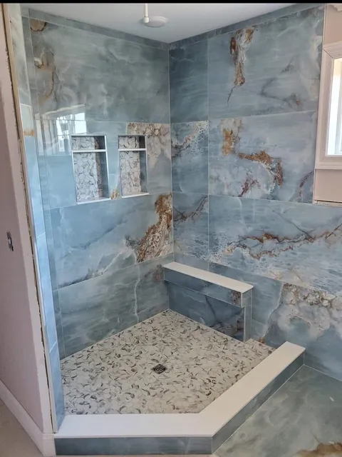 Blue marble-look shower with bench and niches