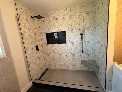Geometric patterned tile shower with dark floor