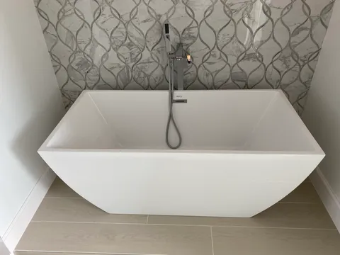 Square freestanding tub on wood-look floor
