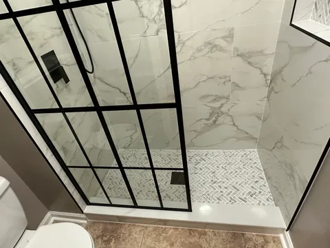 Marble-look shower with black-frame grid glass