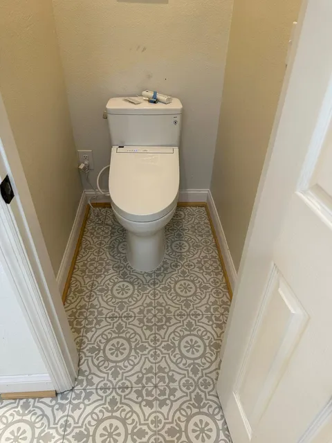 Toilet on gray and white patterned floor tile