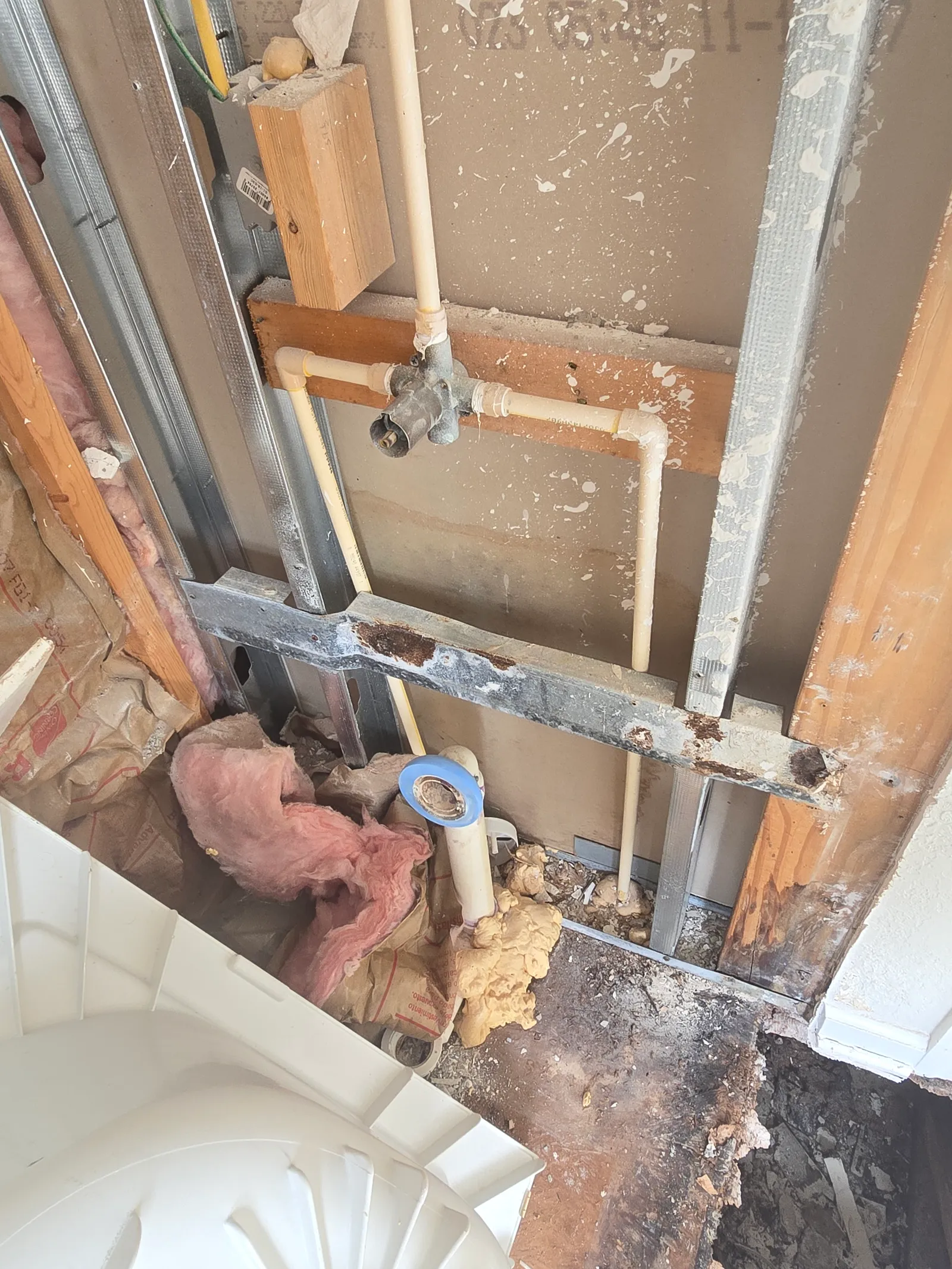 Rotted subfloor and framing exposed under the old shower