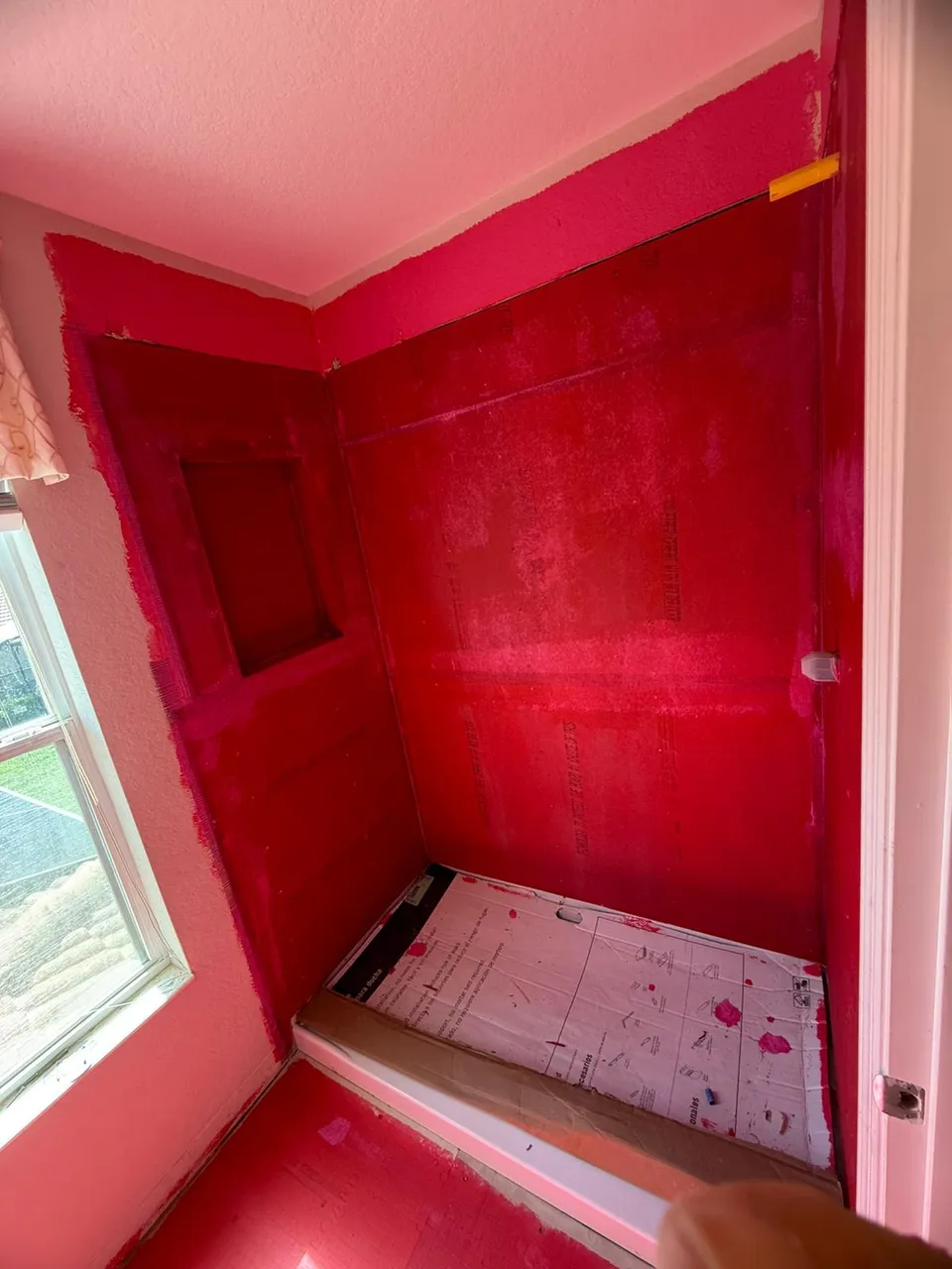 Shower walls coated in red waterproofing membrane
