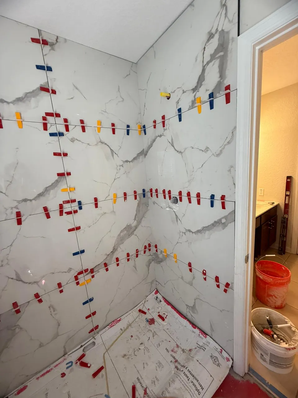 Marble-look tile going up with leveling clips