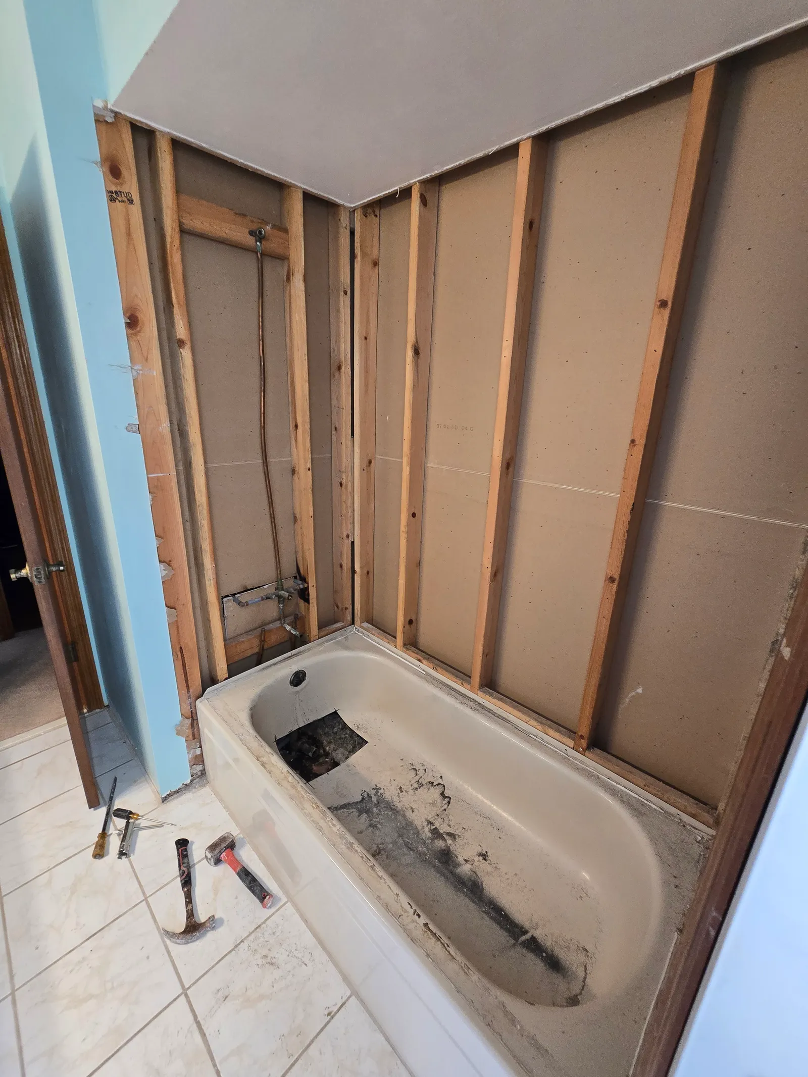 Old tub exposed after the surround was removed