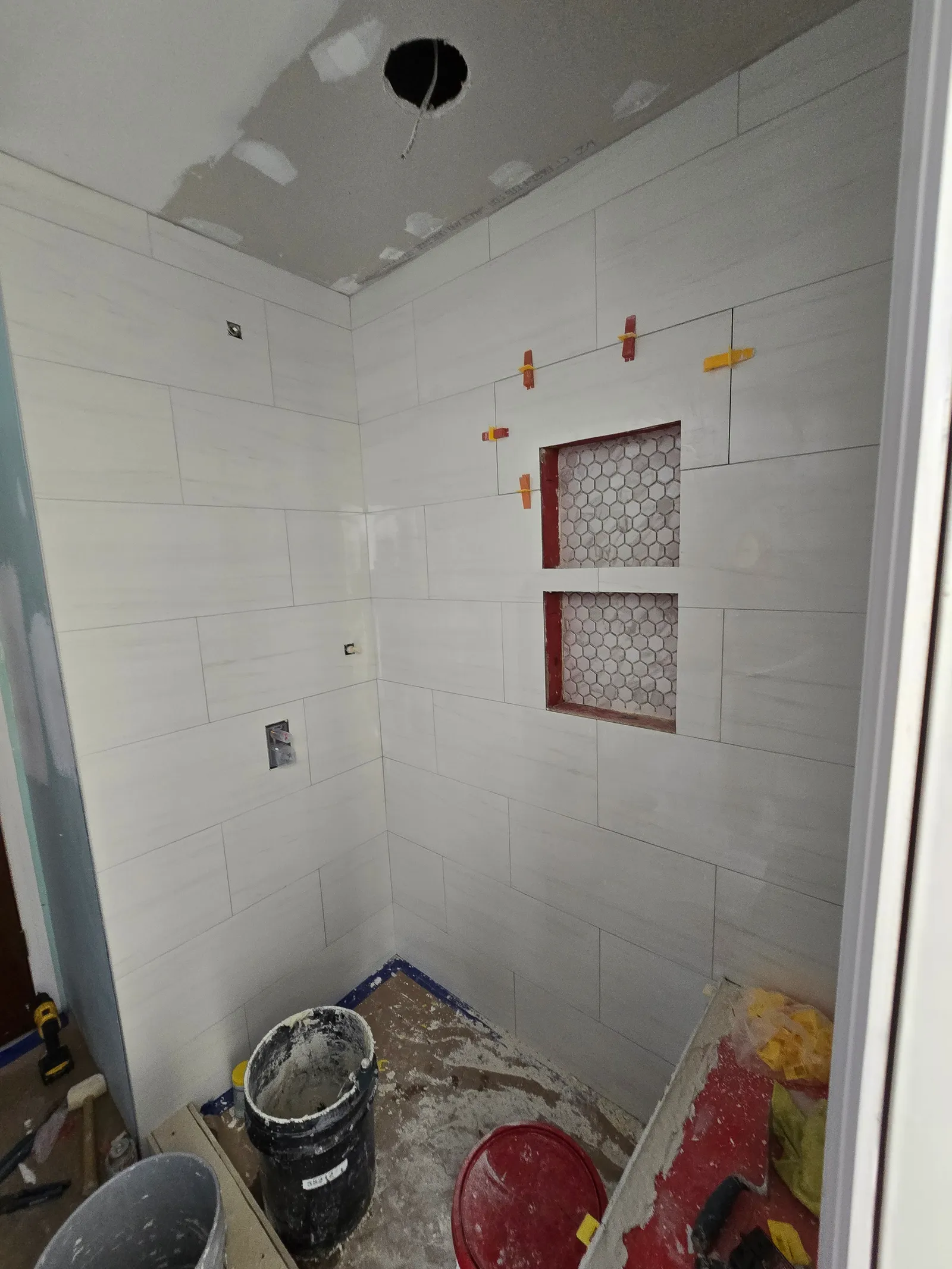 Shower wall tile set with two hexagon mosaic niches, spacers still in place