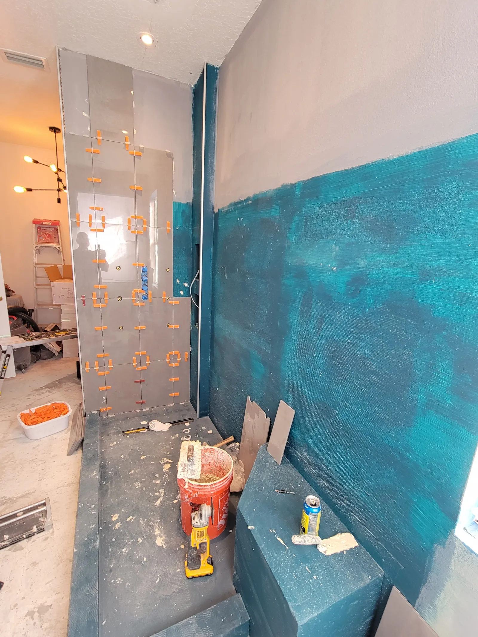 First large-format tile set over the waterproofing membrane with leveling clips