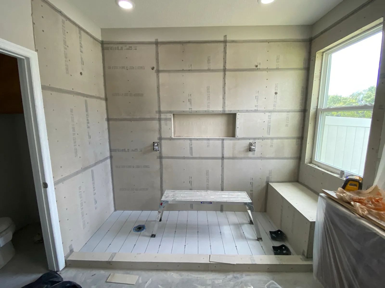 Shower walls covered in cement board before waterproofing